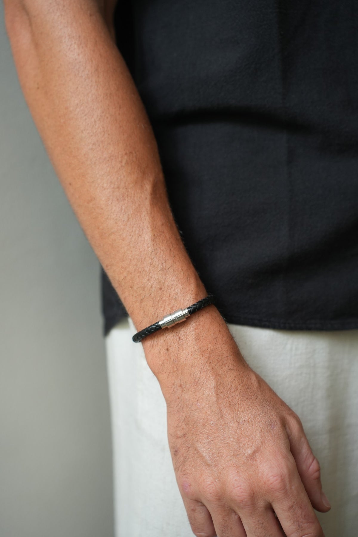 Ethos Black Leather Bracelet worn with a navy T-shirt