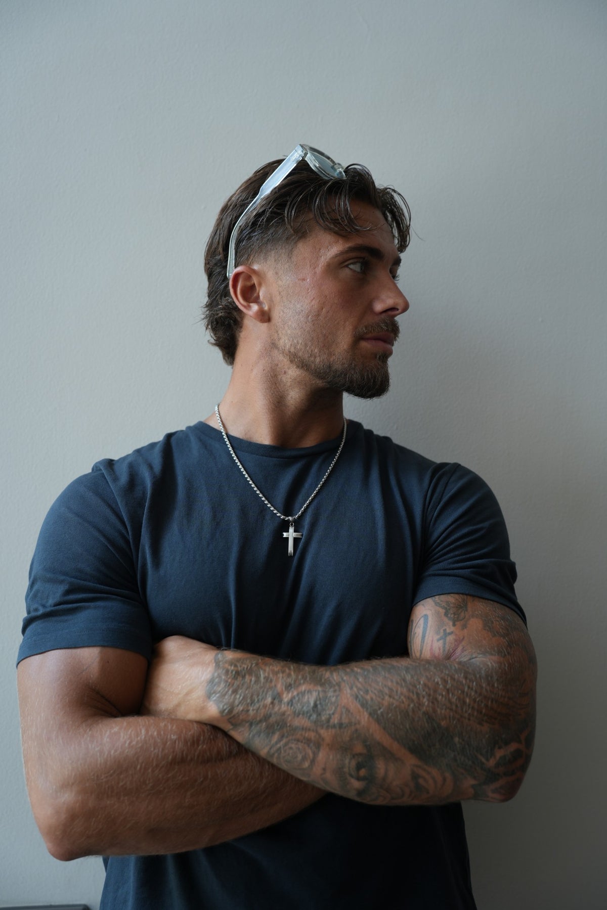 Apex Silver Cross Necklace worn over a navy T-shirt