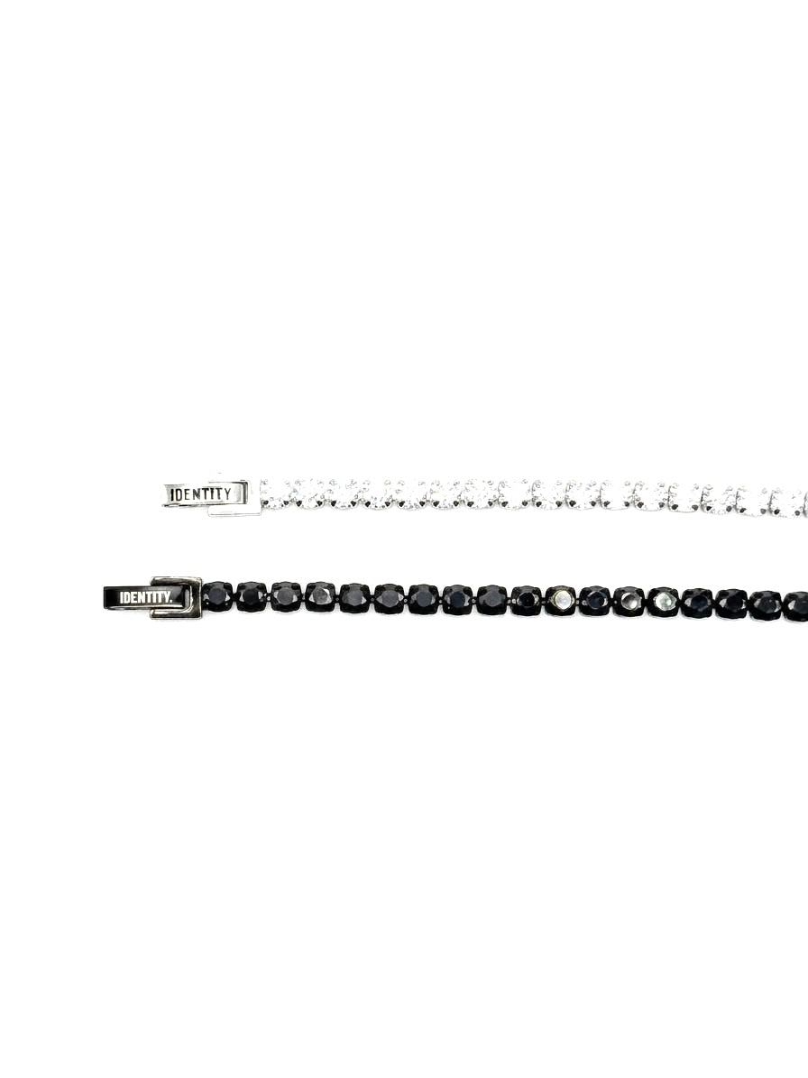 White and black tennis bracelets laid in parallel