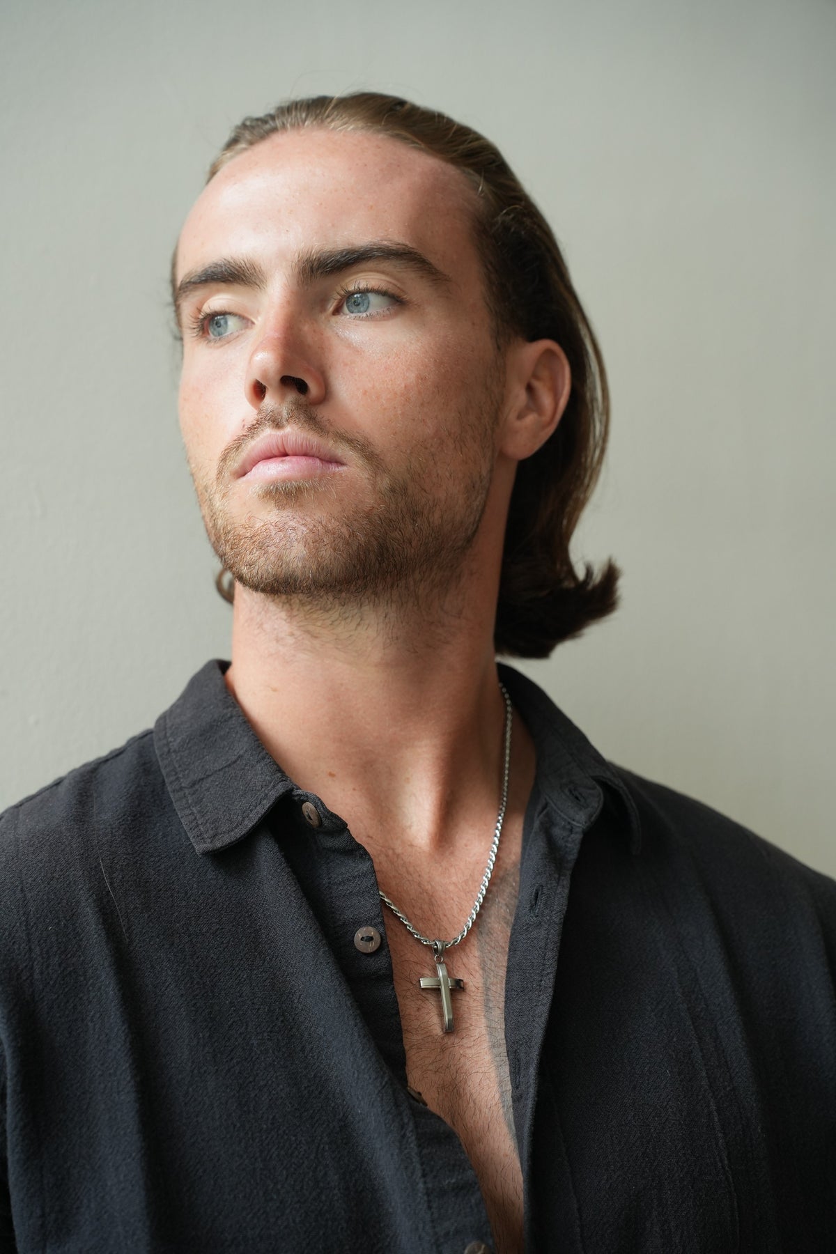 Apex Silver Cross Necklace worn with an open black shirt